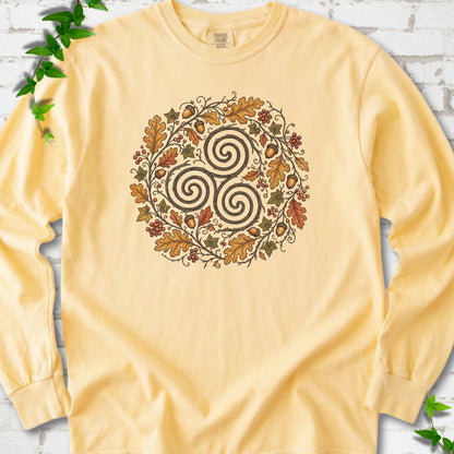Butter Comfort Colors® long sleeve T-shirt flat lay with a Celtic-inspired triskele and autumn oak wreath design.