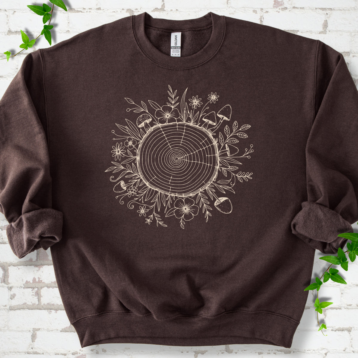 Dark Chocolate classic sweatshirt shown flat with the Circles of Life tree-ring, wildflower and mushroom graphic