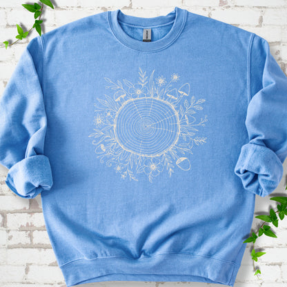 Carolina Blue classic sweatshirt shown flat with the Circles of Life tree-ring, wildflower and mushroom graphic