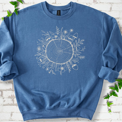 Indigo Blue classic sweatshirt shown flat with the Circles of Life tree-ring, wildflower and mushroom graphic