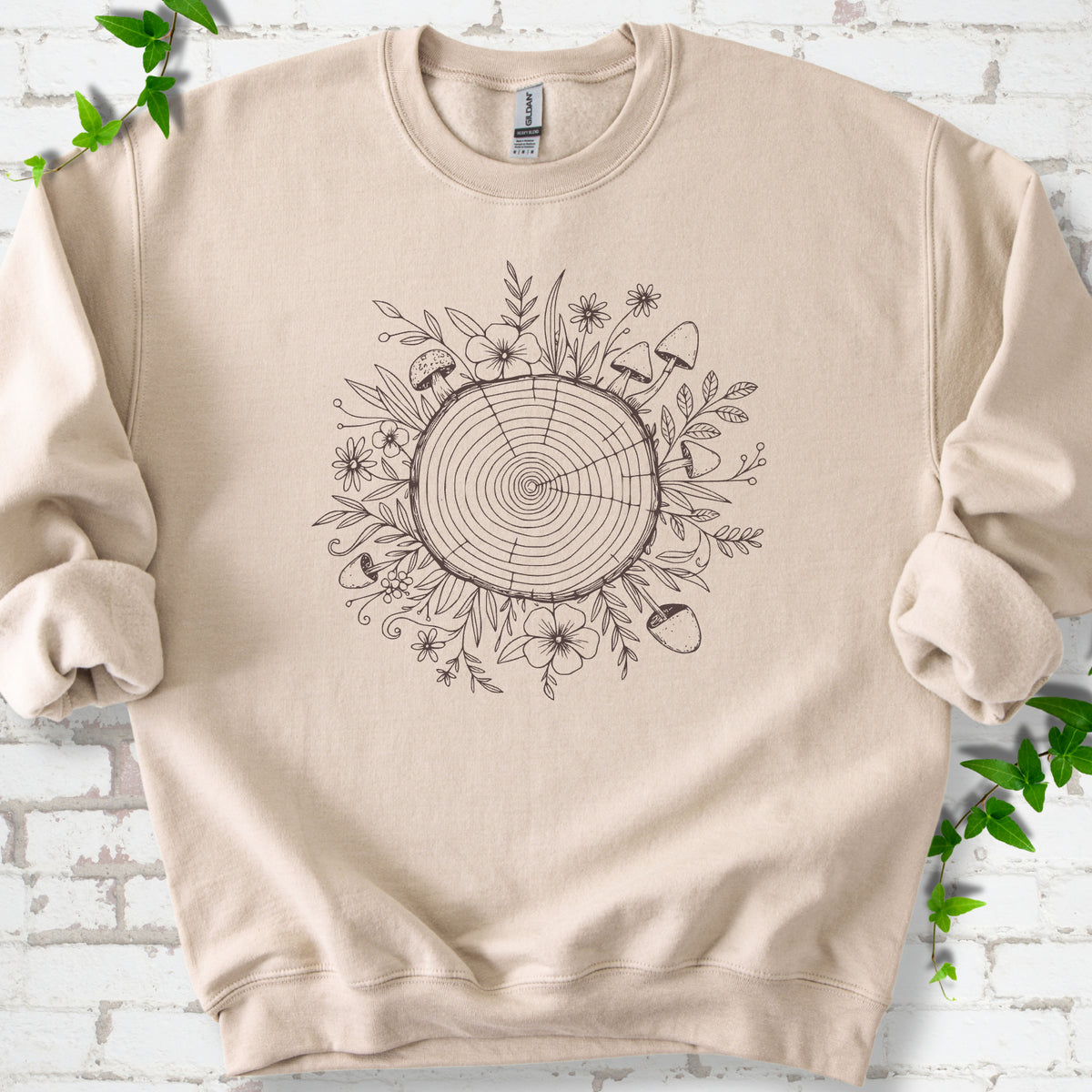 Sand classic sweatshirt shown flat with the Circles of Life tree-ring, wildflower and mushroom graphic