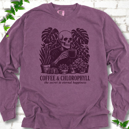 Berry Comfort Colors® long sleeve T-shirt flat lay featuring a distressed skeleton drinking coffee among houseplants