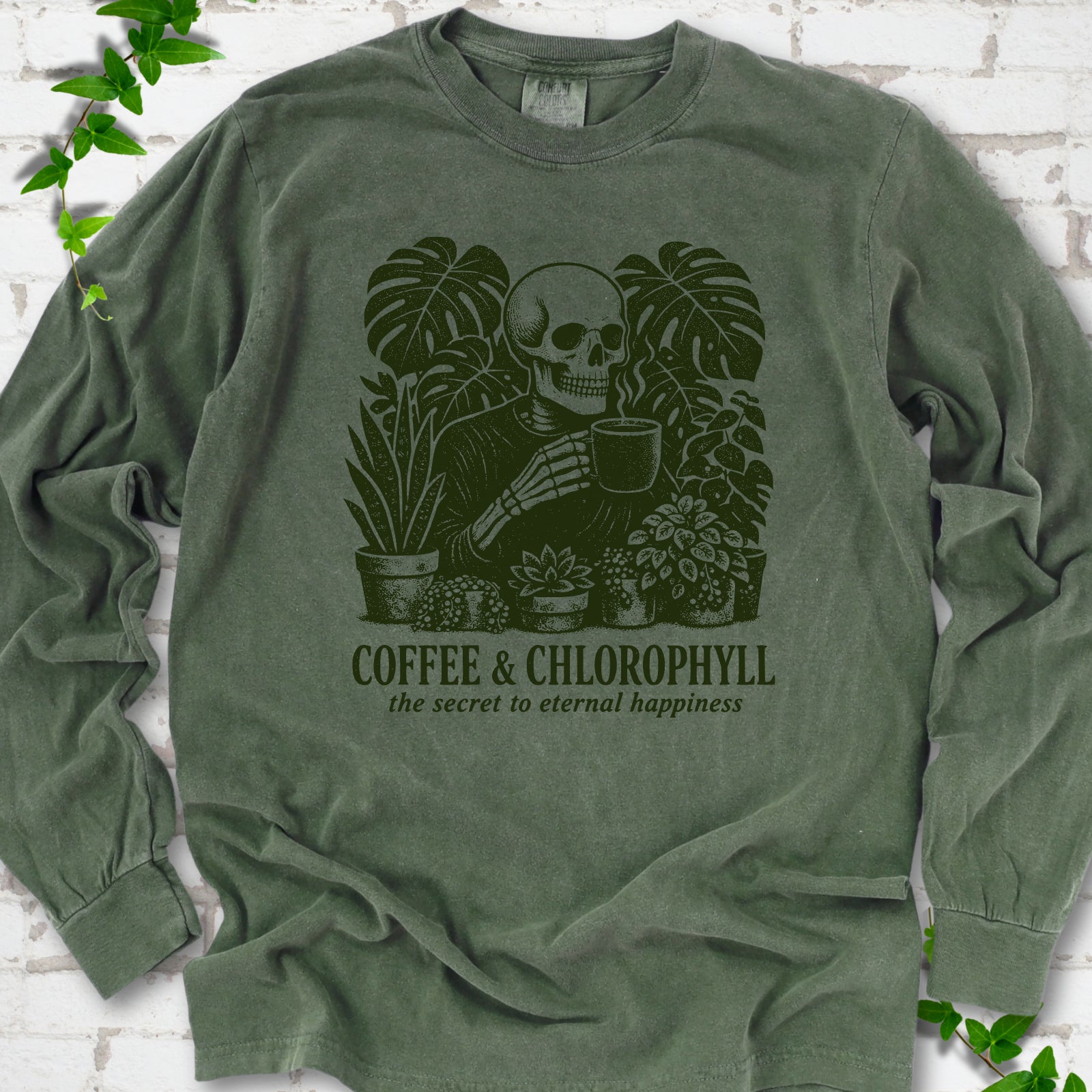 Hemp Comfort Colors® long sleeve T-shirt flat lay featuring a distressed skeleton drinking coffee among houseplants