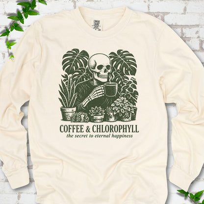 Ivory Comfort Colors® long sleeve T-shirt flat lay featuring a distressed skeleton drinking coffee among houseplants