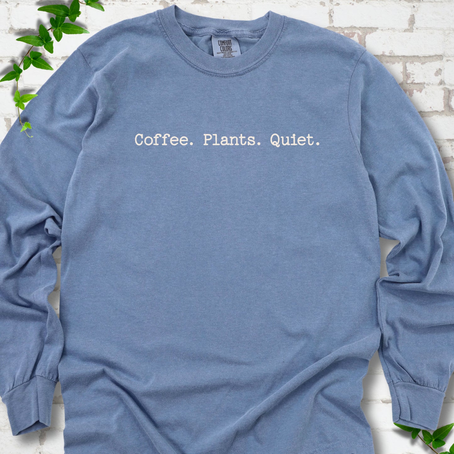 Blue Jean Comfort Colors® long sleeve T-shirt showing the Coffee. Plants. Quiet. text design