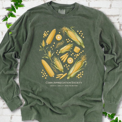 Hemp Comfort Colors® long sleeve T-shirt flat lay featuring ears, kernels and corn plants with text "Corn Appreciation Society" and "Grow it, grill it, pass the butter"