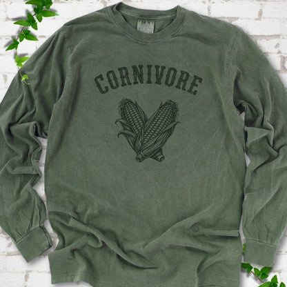 Hemp Comfort Colors® long sleeve T-shirt flat lay featuring black line art of two sweet corn cobs beneath the word "Cornivore"