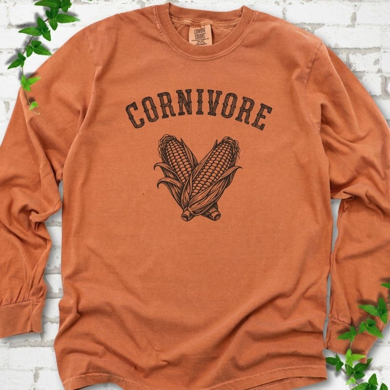 Yam Comfort Colors® long sleeve T-shirt flat lay featuring black line art of two sweet corn cobs beneath the word "Cornivore"