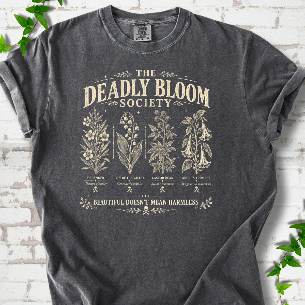 Pepper Comfort Colors® T-shirt flat lay featuring The Deadly Bloom Society poisonous plant design.