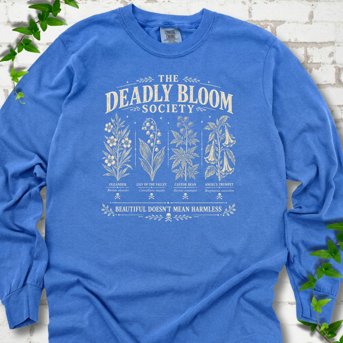 Flo Blue Comfort Colors® long sleeve T-shirt flat lay featuring The Deadly Bloom Society poisonous plant design.