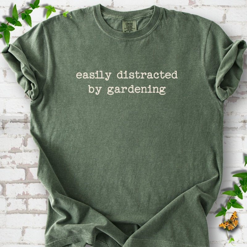 Moss Comfort Colors® T-shirt with Easily Distracted by Gardening text design.
