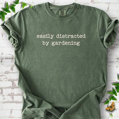 Moss Comfort Colors® T-shirt with Easily Distracted by Gardening text design.