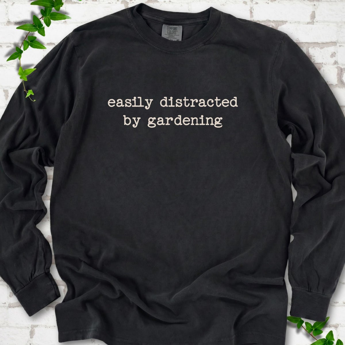 Black Comfort Colors® long sleeve shirt with Easily Distracted by Gardening text design.