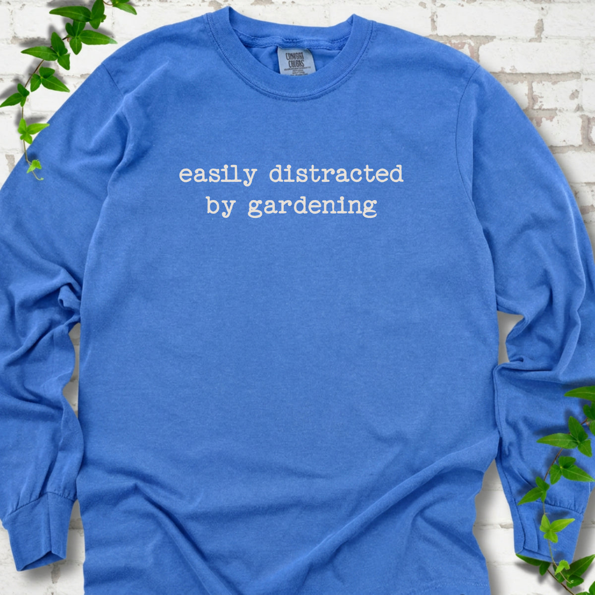 Crunchberry Comfort Colors® long sleeve shirt with Easily Distracted by Gardening text design.