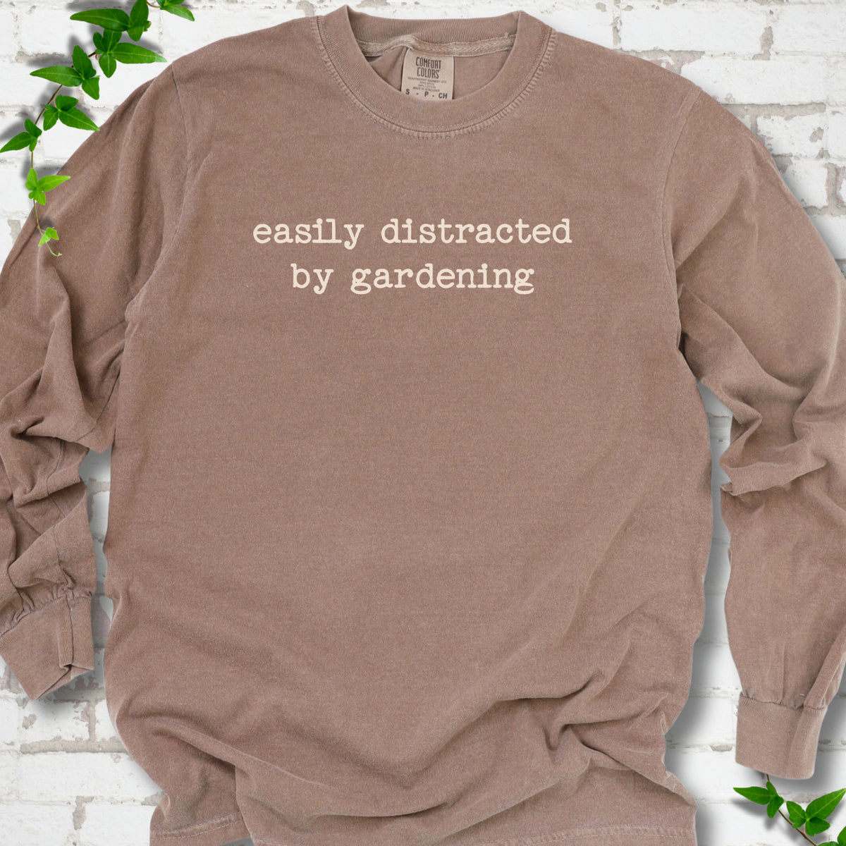 Espresso Comfort Colors® long sleeve shirt with Easily Distracted by Gardening text design.