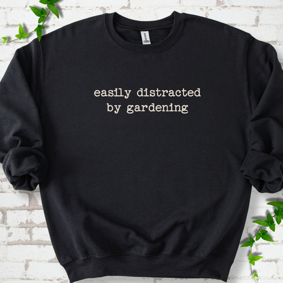Black classic sweatshirt with Easily Distracted by Gardening text design.