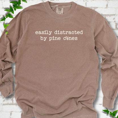 Espresso Comfort Colors® long sleeve T-shirt shown flat with "Easily Distracted by Pine Cones" text and a small pine cone graphic