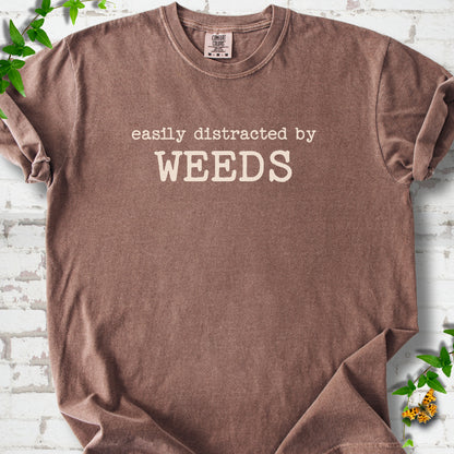 Espresso Comfort Colors® T-shirt shown flat with cream "Easily Distracted by Weeds" gardening slogan