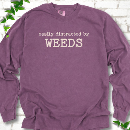 Berry Comfort Colors® long sleeve T-shirt shown flat with cream "Easily Distracted by Weeds" gardening slogan