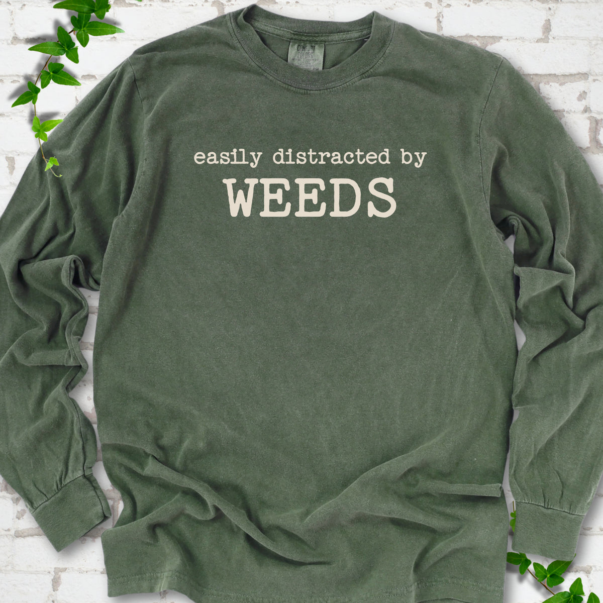 Hemp Comfort Colors® long sleeve T-shirt shown flat with cream "Easily Distracted by Weeds" gardening slogan