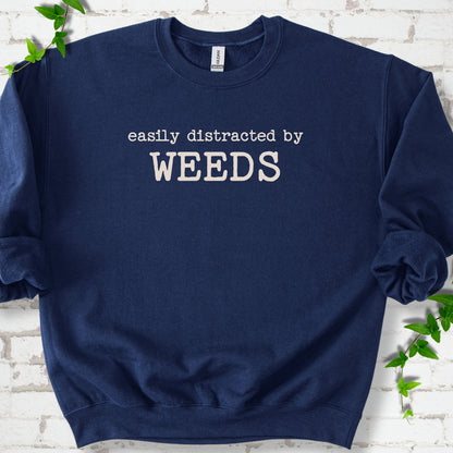 Navy classic sweatshirt shown flat with cream "Easily Distracted by Weeds" gardening slogan