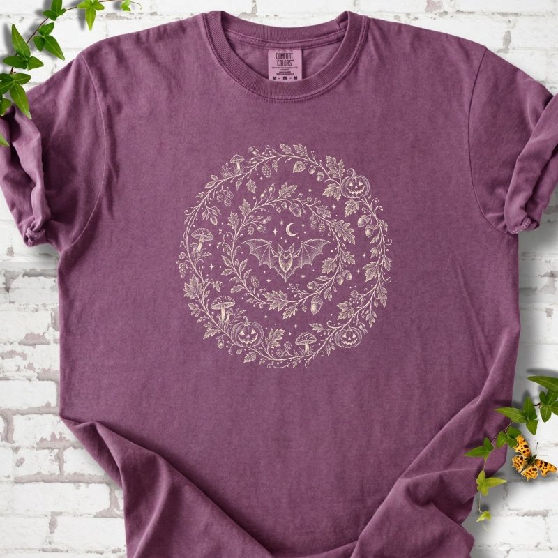 Berry Comfort Colors® T-shirt with cream botanical autumn wreath graphic featuring mushrooms, pumpkins, a bat and crescent moon