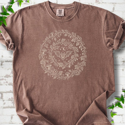 Espresso Comfort Colors® T-shirt with cream botanical autumn wreath graphic featuring mushrooms, pumpkins, a bat and crescent moon