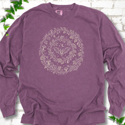 Berry Comfort Colors® long sleeve T-shirt with cream botanical autumn wreath graphic featuring mushrooms, pumpkins, a bat and crescent moon