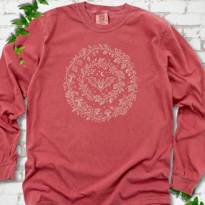 Crimson Comfort Colors® long sleeve T-shirt with cream botanical autumn wreath graphic featuring mushrooms, pumpkins, a bat and crescent moon