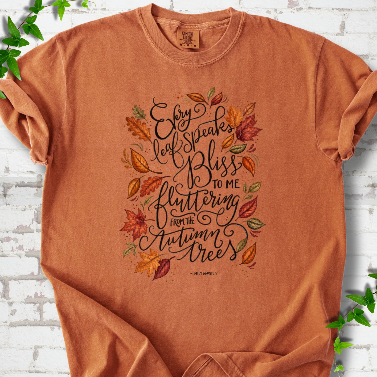 Yam Comfort Colors® T-shirt flat lay with the Every Leaf Speaks Bliss Emily Brontë quote and autumn leaves.