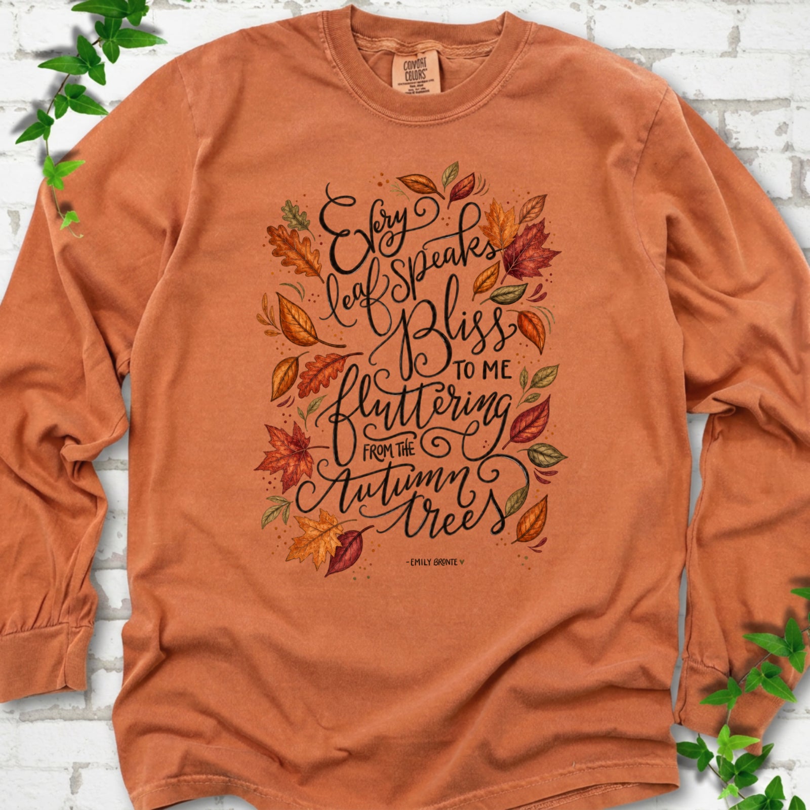 Yam Comfort Colors® long sleeve T-shirt flat lay with the Every Leaf Speaks Bliss Emily Brontë quote and autumn leaves.