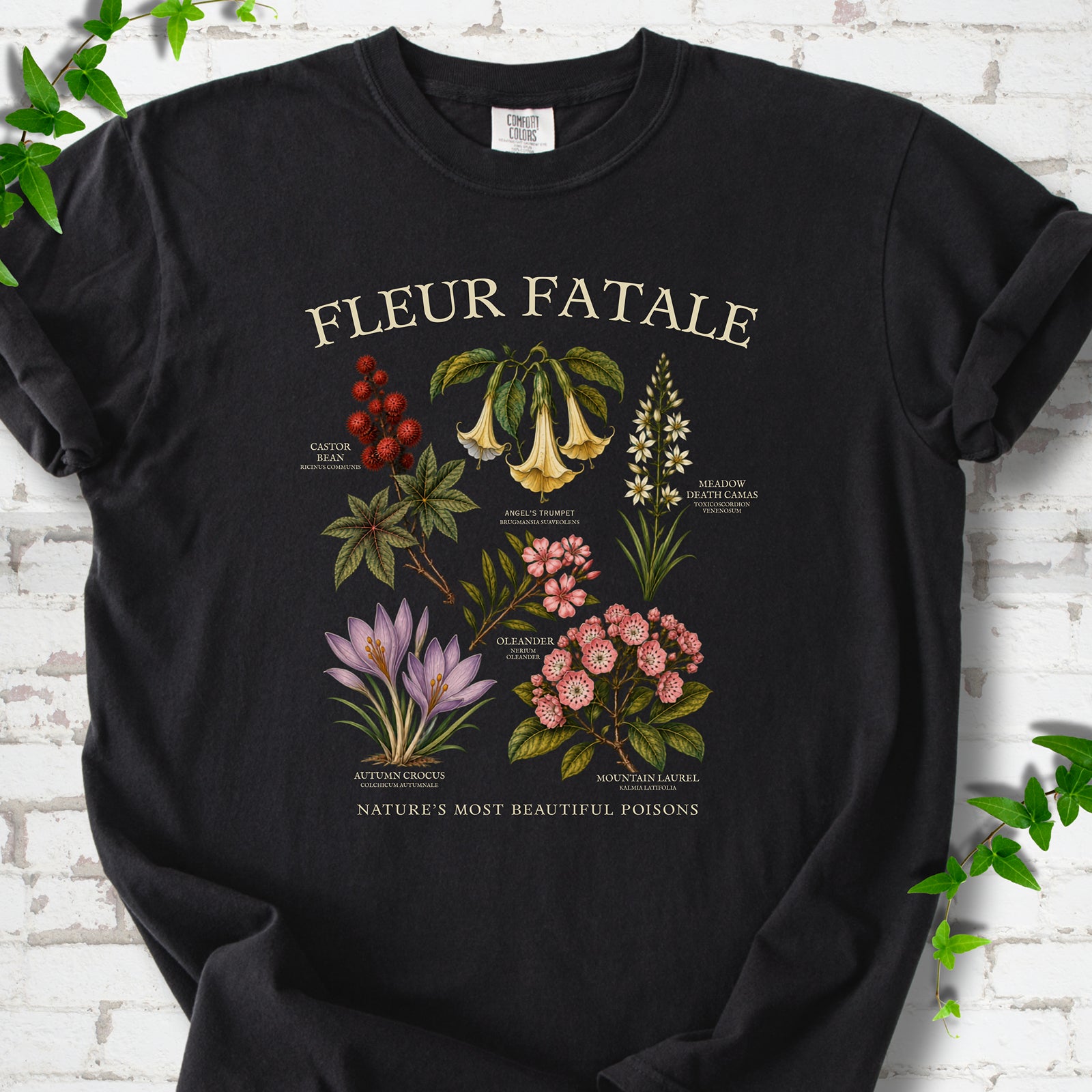 Black Comfort Colors® T-shirt flat lay featuring a Fleur Fatale botanical chart of six poisonous flowering plants.
