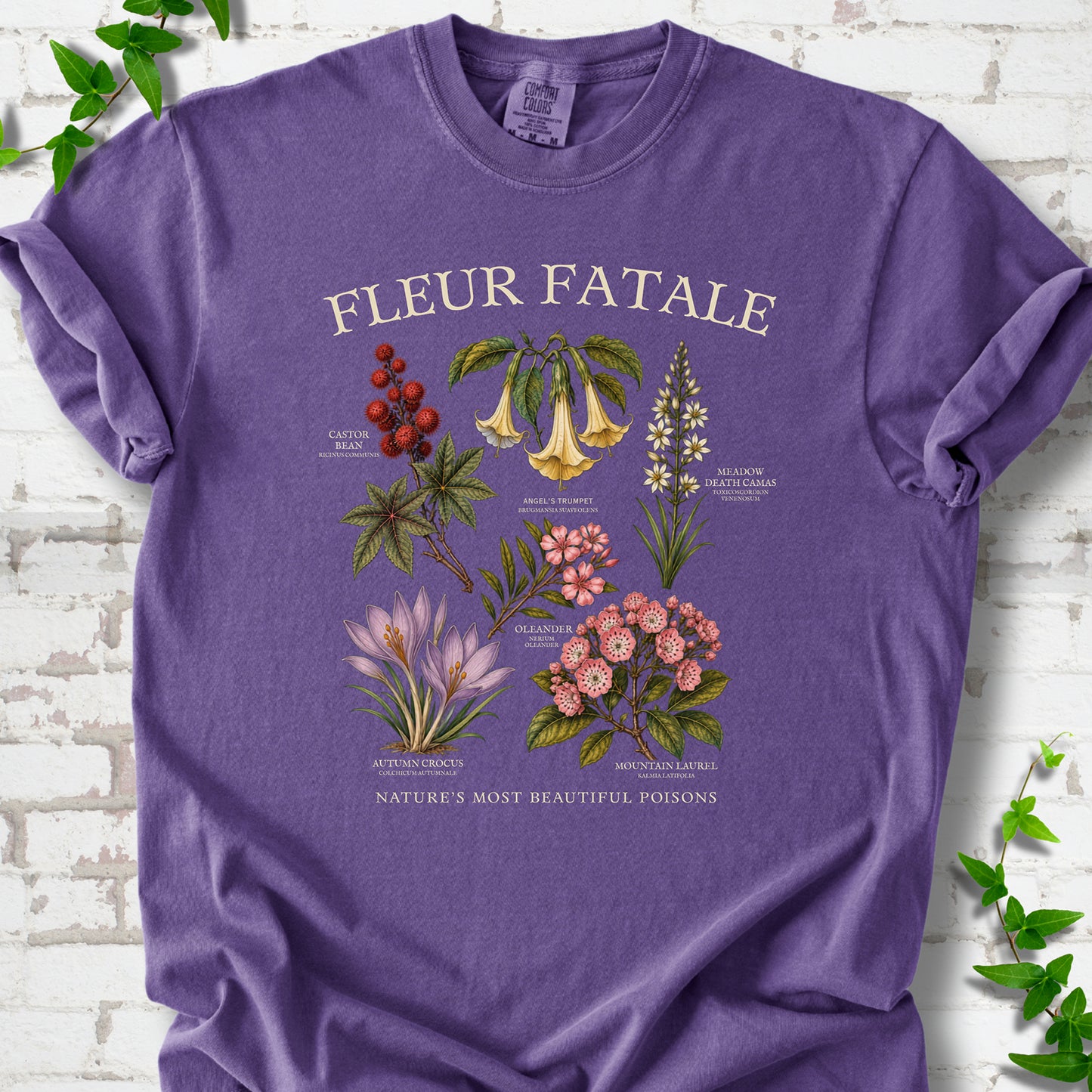 Grape Comfort Colors® T-shirt flat lay featuring a Fleur Fatale botanical chart of six poisonous flowering plants.