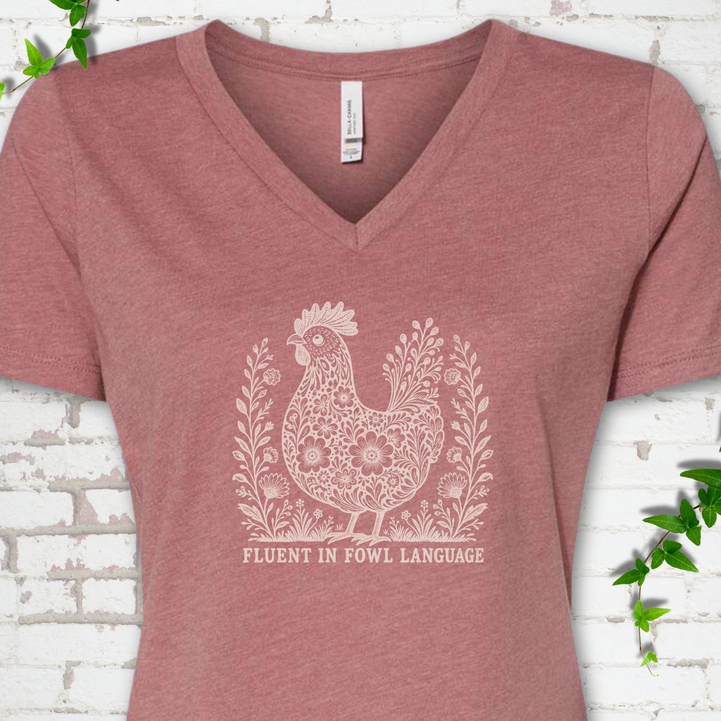 Heather Mauve Bella Canvas® V-neck T-shirt with cream floral hen and Fluent in Fowl Language text