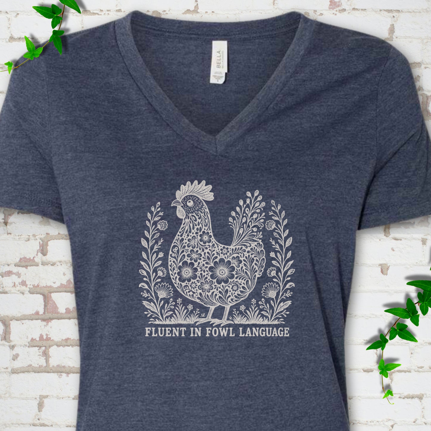 Heather Navy Bella Canvas® V-neck T-shirt with cream floral hen and Fluent in Fowl Language text