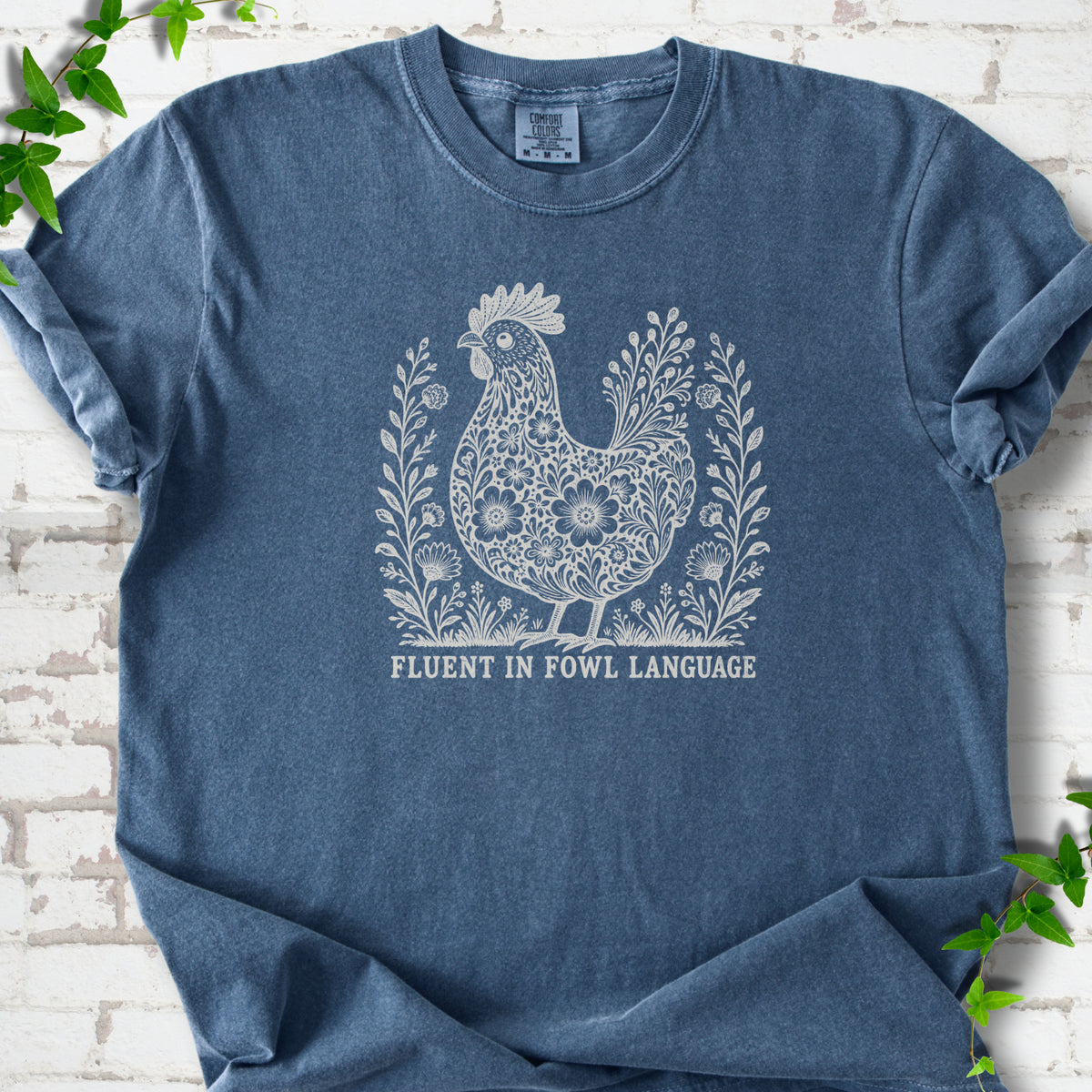 Denim Comfort Colors® T-shirt with cream floral hen and Fluent in Fowl Language text