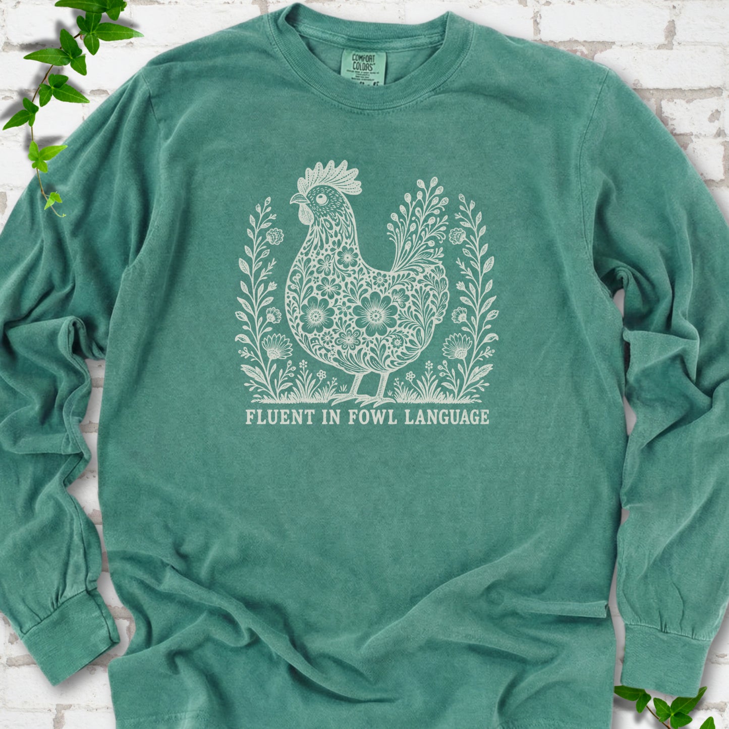 Light Green Comfort Colors® long sleeve T-shirt with cream floral hen and Fluent in Fowl Language text