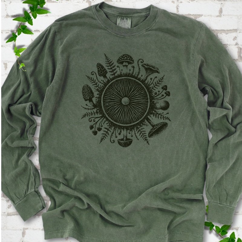 Hemp green long-sleeve tee with a mushroom gill circle ringed by ferns, morels and mushrooms in dark green ink.