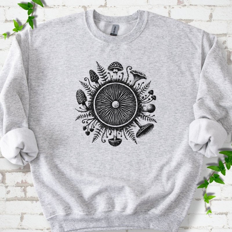 Ash gray crewneck sweatshirt with a mushroom gill circle ringed by ferns, morels and mushrooms in black ink.