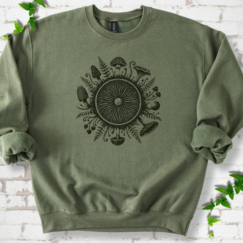 Military green crewneck sweatshirt with a mushroom gill circle ringed by ferns, morels and mushrooms in dark green ink.