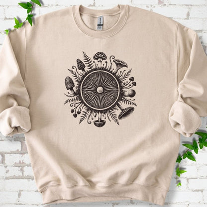 Sand crewneck sweatshirt with a mushroom gill circle ringed by ferns, morels and mushrooms in dark brown ink.