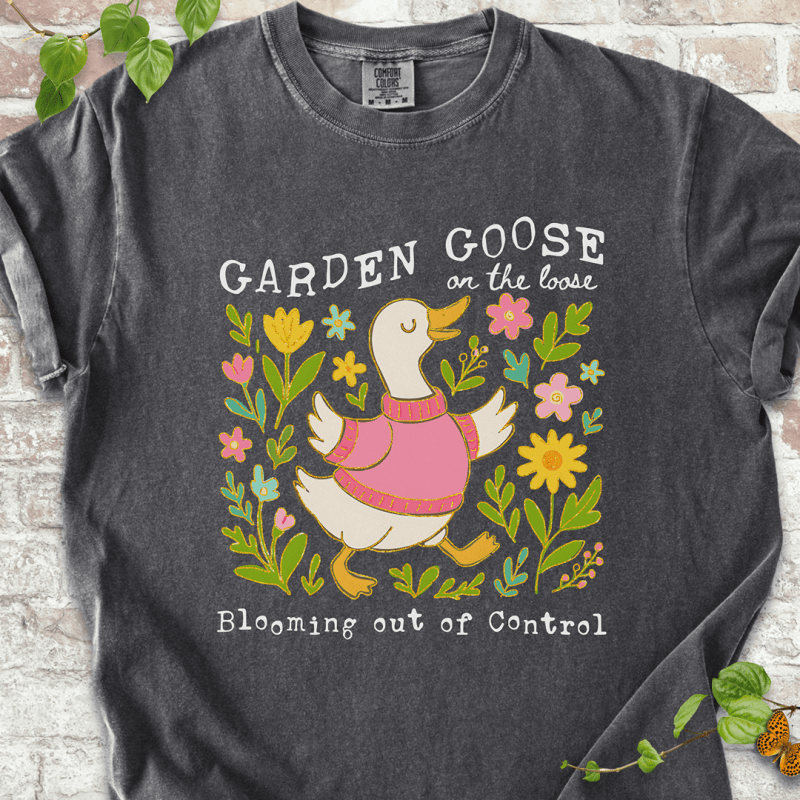 Silly gardening goose graphic on a pepper Comfort Colors™ T-shirt with a flower-loving goose in full bloom.