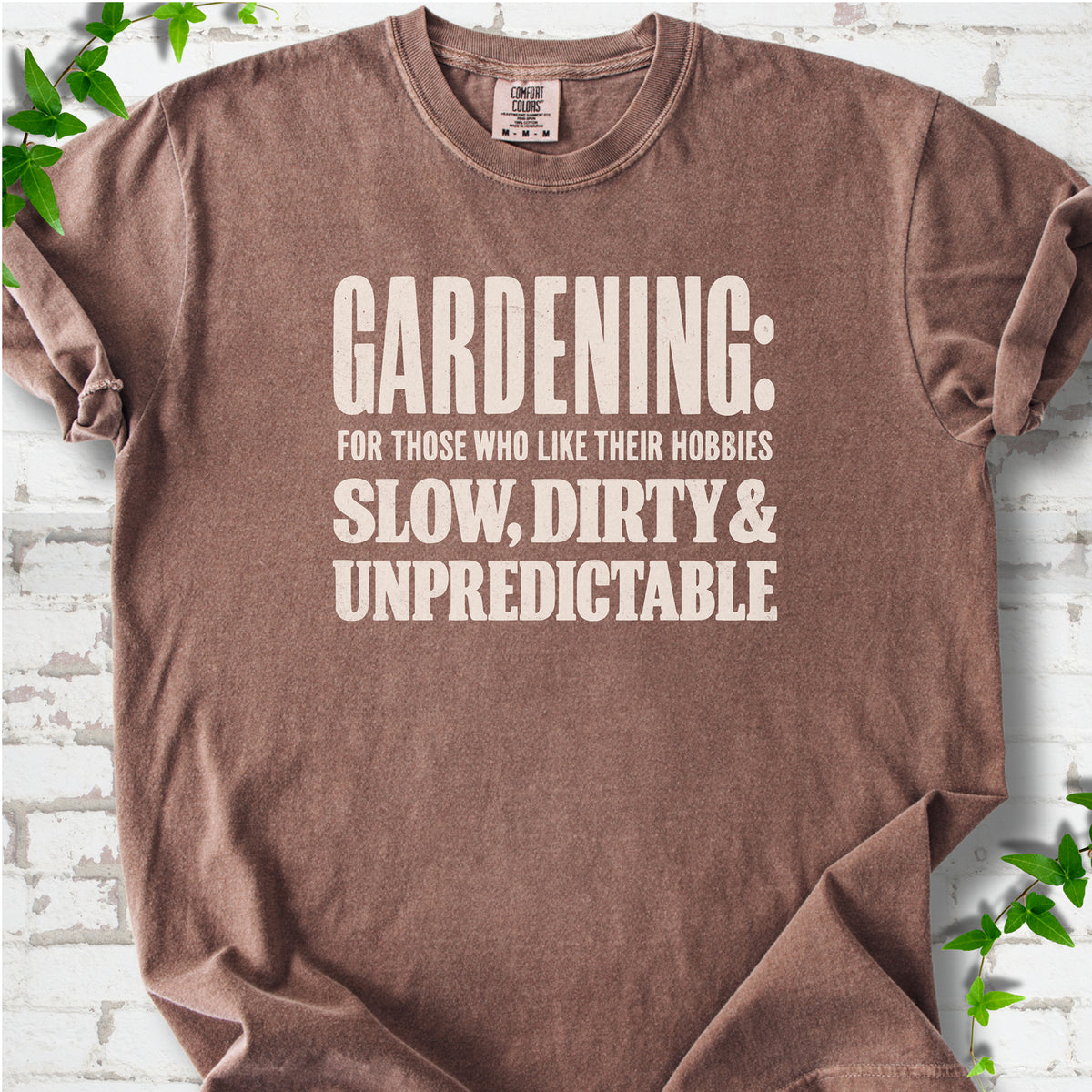 Espresso Comfort Colors® T-shirt with white “Gardening: For Those Who Like Their Hobbies Slow, Dirty & Unpredictable” typography