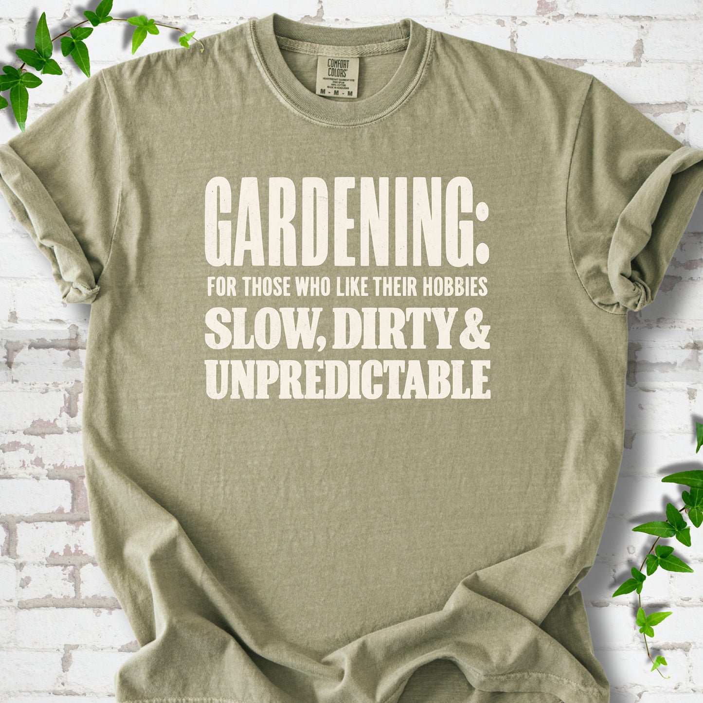 Khaki Comfort Colors® T-shirt with white “Gardening: For Those Who Like Their Hobbies Slow, Dirty & Unpredictable” typography