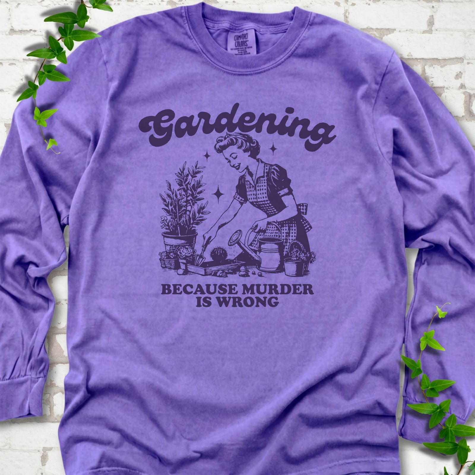 Violet Comfort Colors® long sleeve T-shirt flat lay with retro Gardening Because Murder is Wrong artwork.