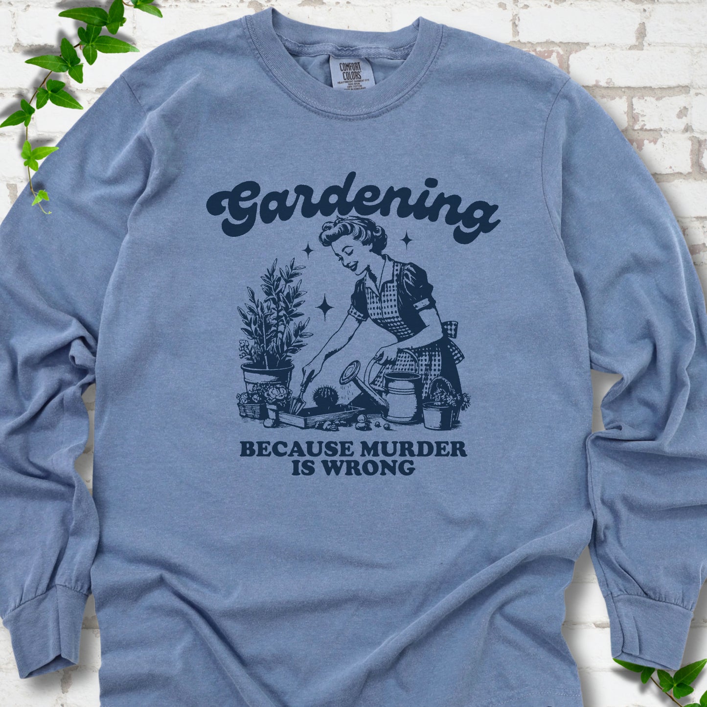 Blue Jean Comfort Colors® long sleeve T-shirt flat lay with retro Gardening Because Murder is Wrong artwork.