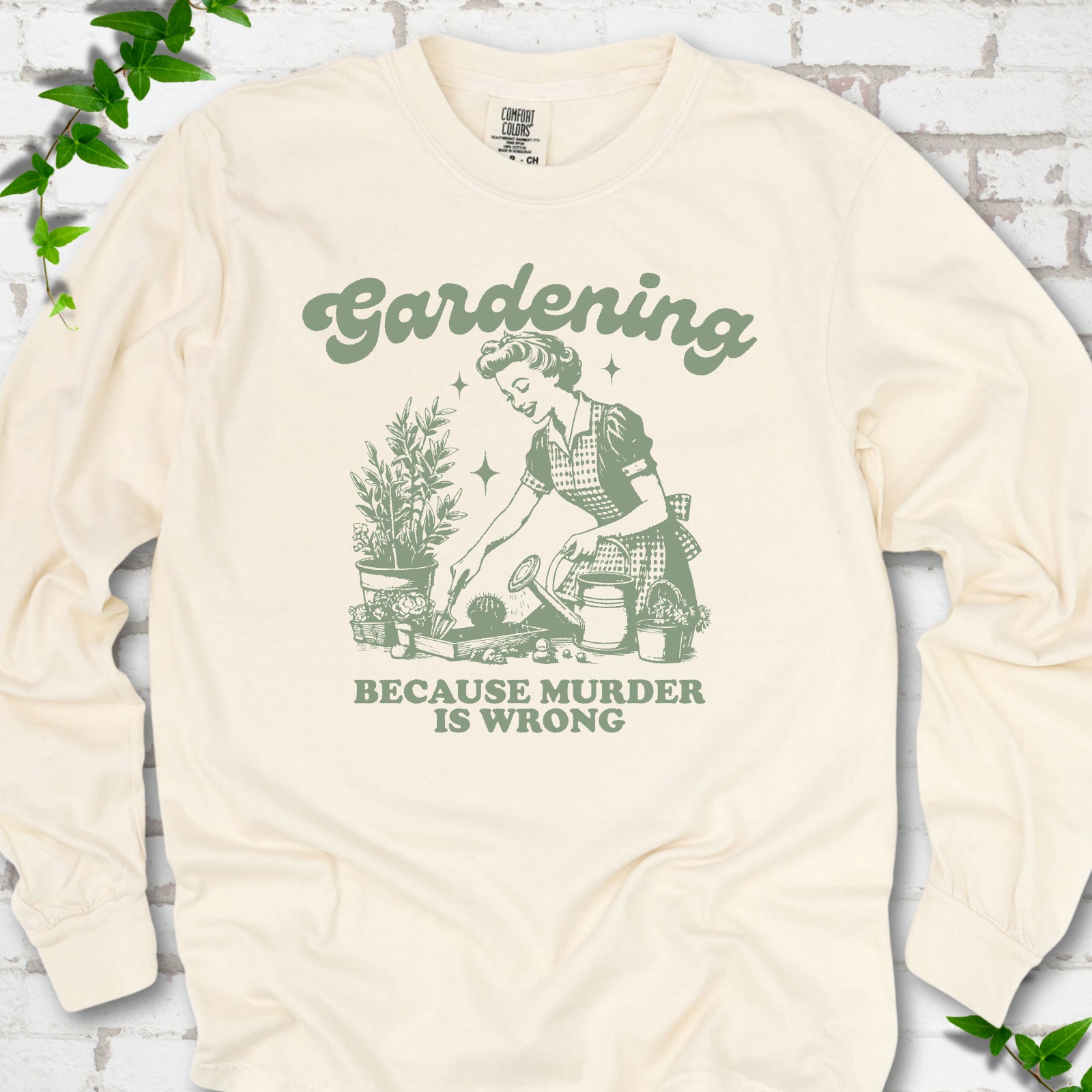 Ivory Comfort Colors® long sleeve T-shirt flat lay with retro Gardening Because Murder is Wrong artwork.