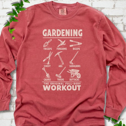 Crimson Comfort Colors® long sleeve T-shirt flat lay featuring a distressed Gardening full-body workout design with labelled garden tools and wheelbarrow.
