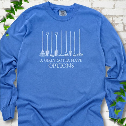 Flo Blue Comfort Colors® long sleeve T-shirt with A Girl's Gotta Have Options garden tools graphic