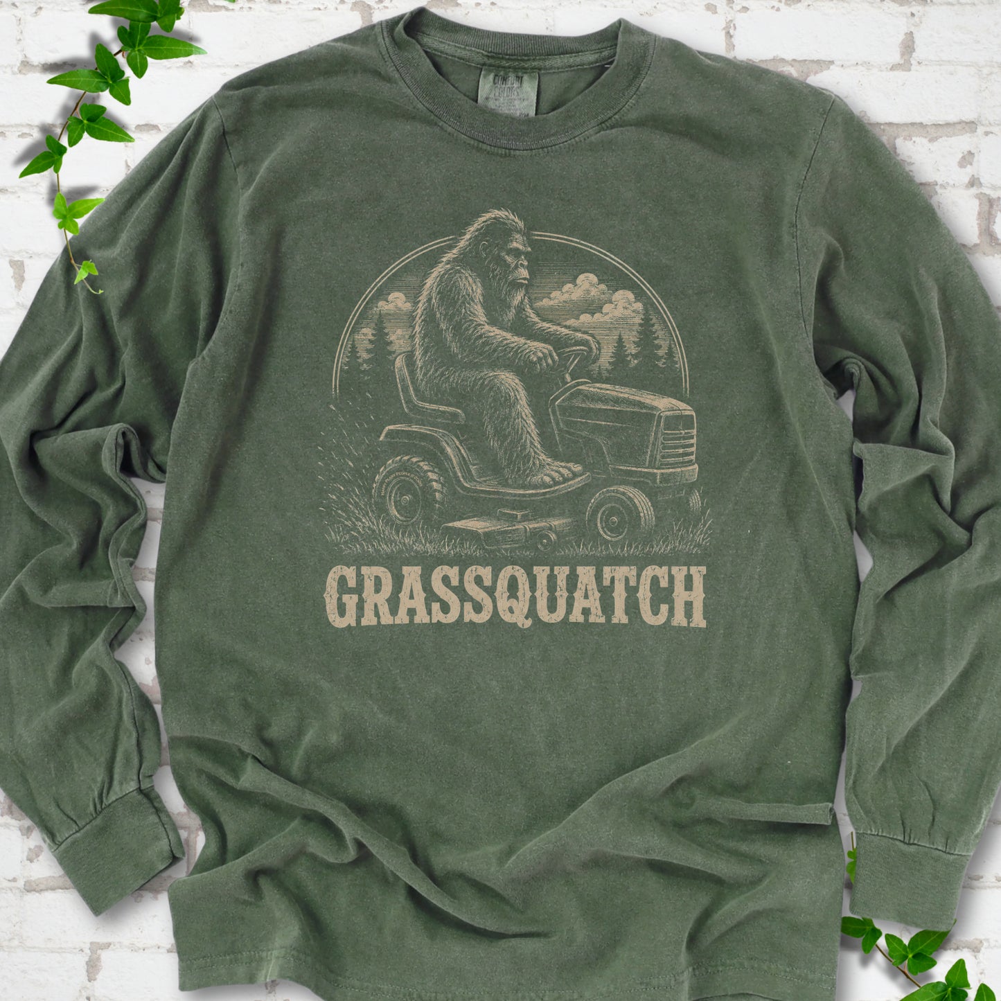 Hemp Comfort Colors® long sleeve T-shirt front mockup featuring Bigfoot riding a lawn mower above the word Grassquatch.